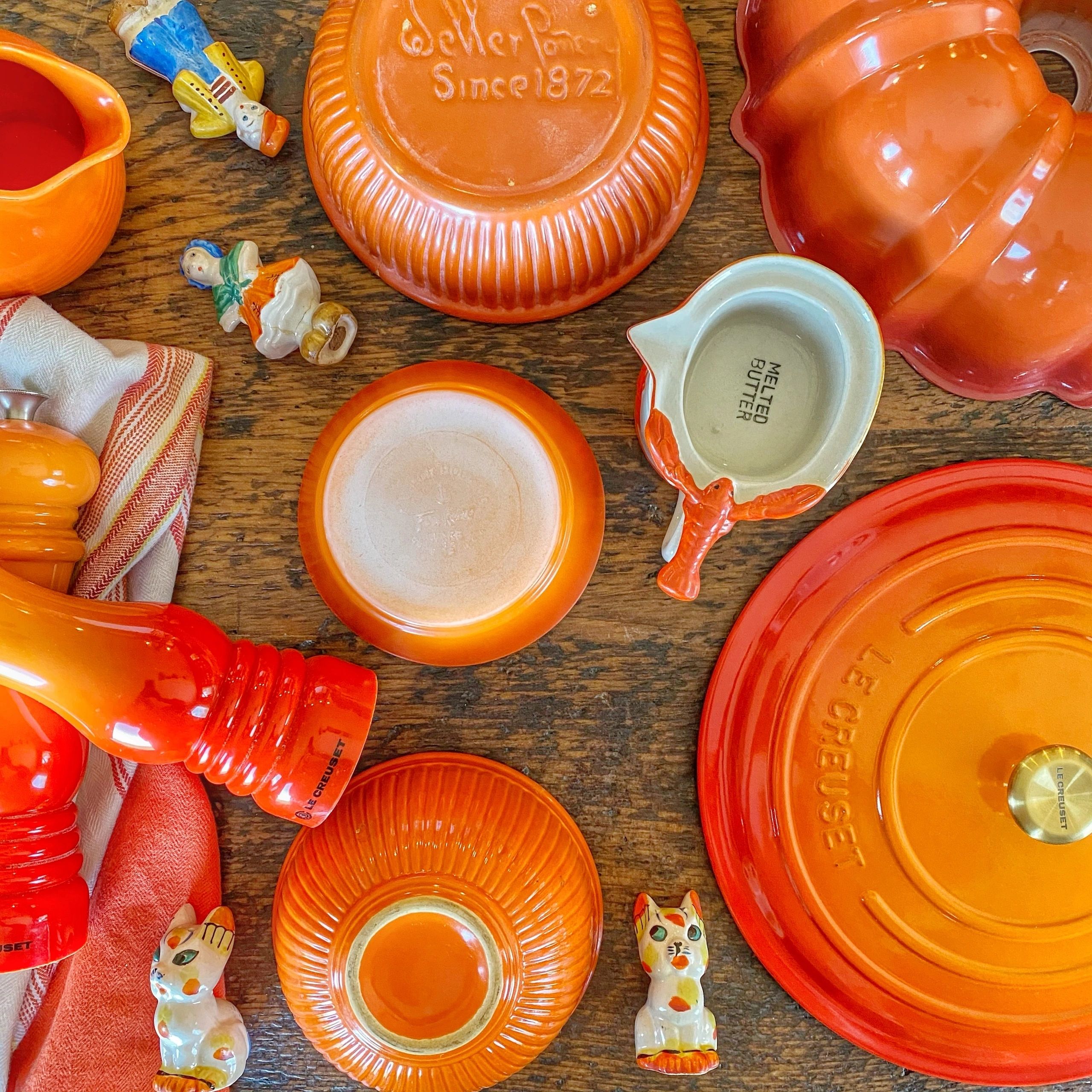 Le Creuset orange and red cookware flat lay
